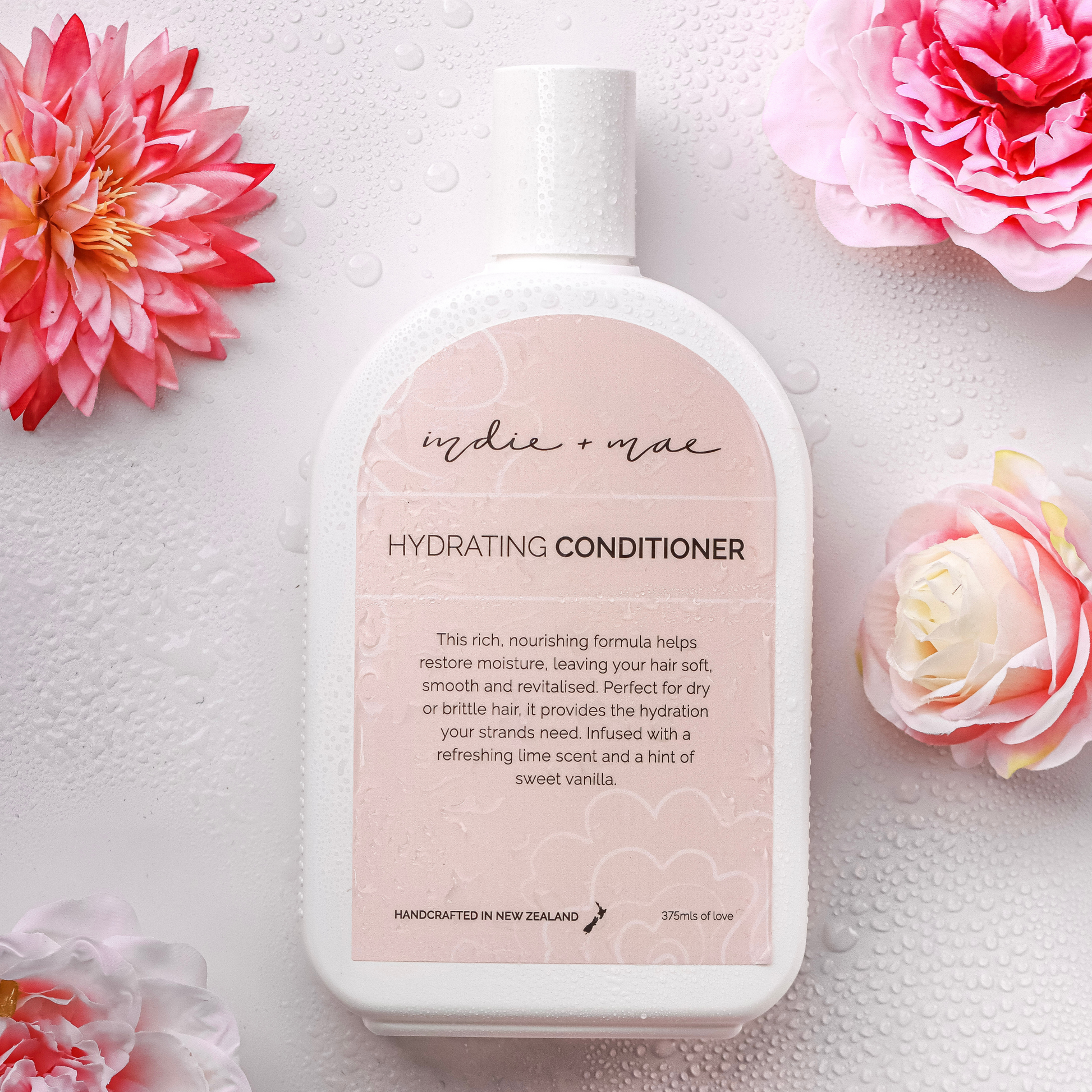 Hydrating conditioner bottle with pink flowers on a light background | Indie + Mae