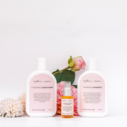 Indie & Mae hair care products with flowers on a white background | Indie + Mae