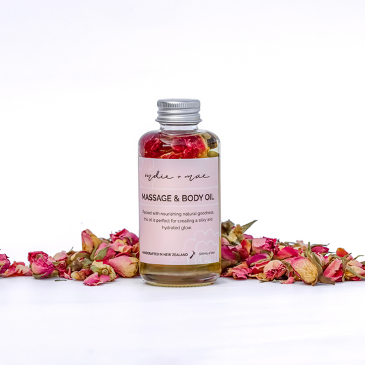 Massage and body oil bottle with pink flowers on a white background | Indie + Mae