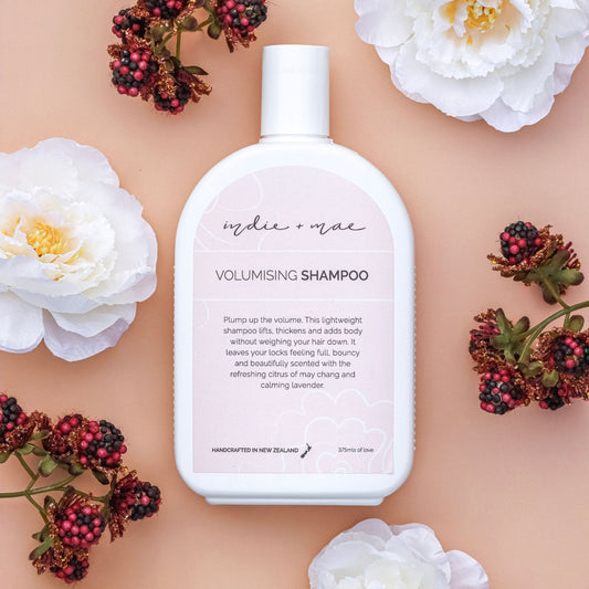 Volumising shampoo bottle with flowers on a beige background | Indie + Mae